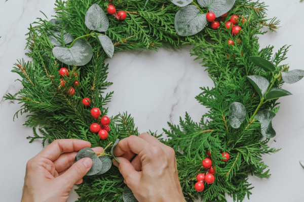 Mann dekoriert Adventkranz