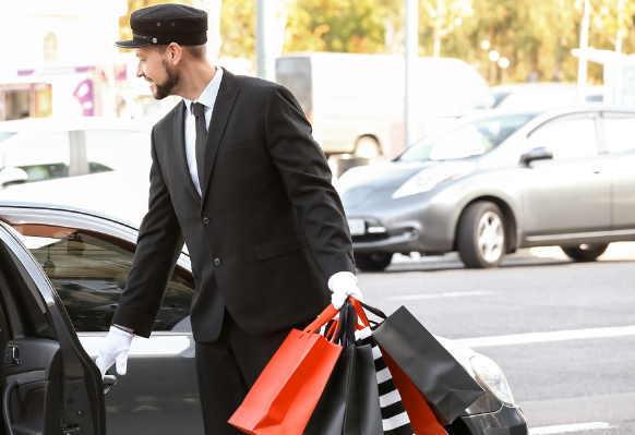 Mann der Einkaufstaschen zum Auto trägt