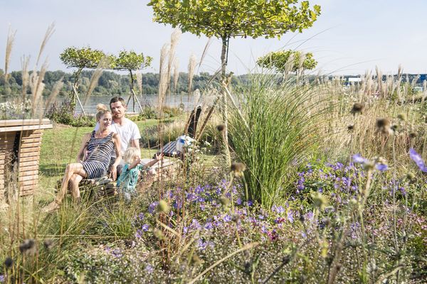 Junge Familie entspannt an der blühenden Donaulände in Tulln
